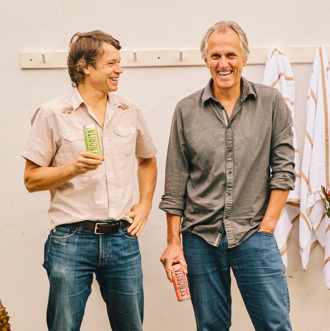 Joel Gott and Charles Bieler laughing together, each holding a can of Se&ntilde;orita
